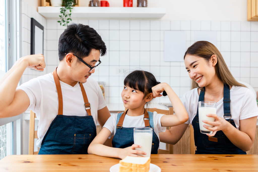 family drinking milk and flexing their arms